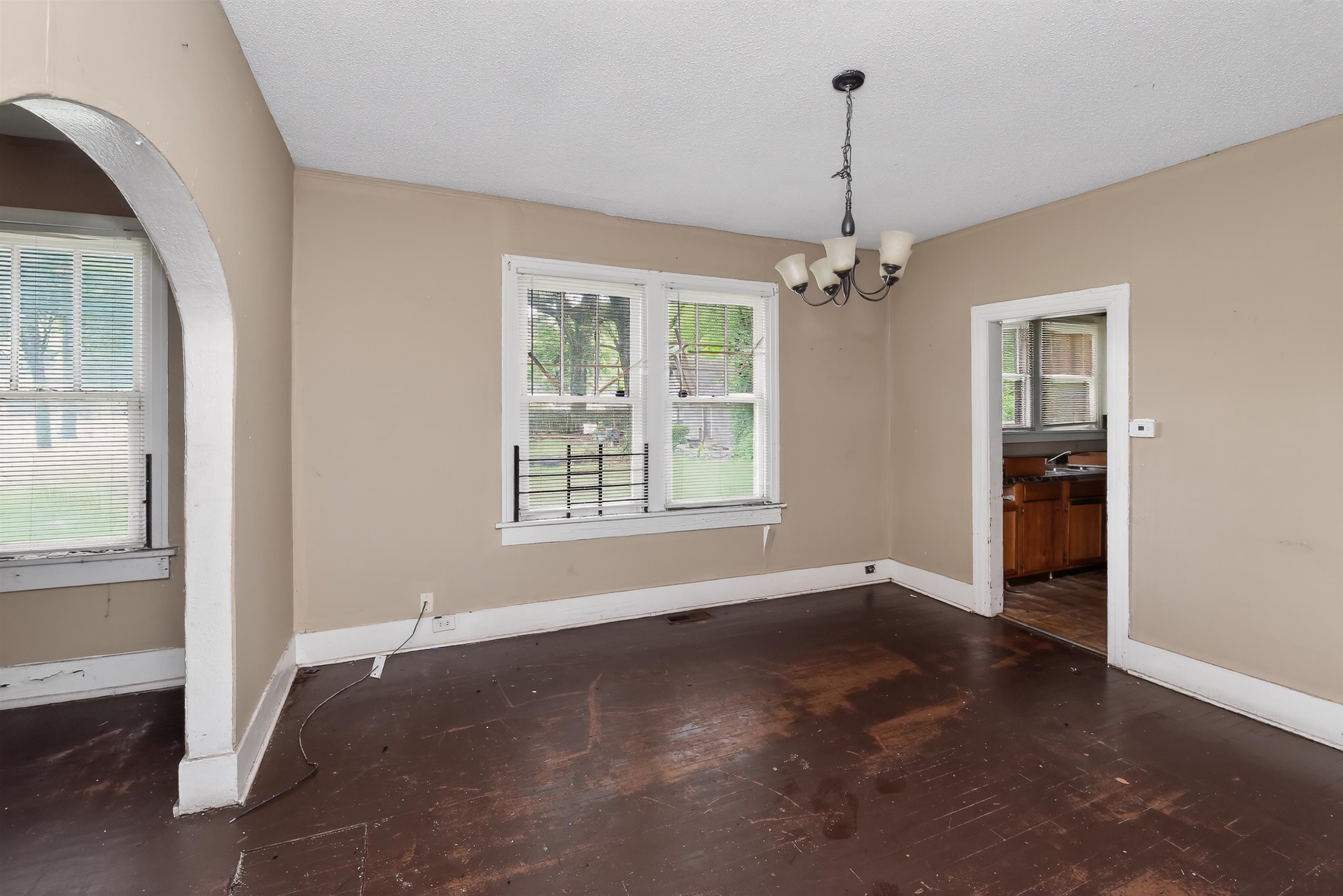 810 Hale Road Memphis, TN 38116 - Photo 16 of 30 Spacious interior room featuring multiple windows, a ceiling-mounted light fixture, and an arched doorway