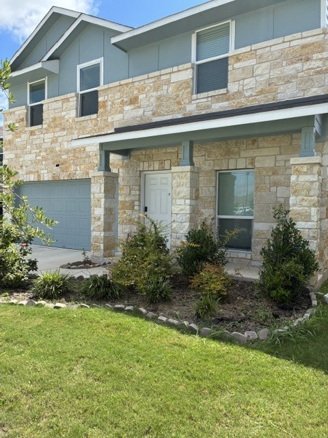 233 Perfect World Loop Jarrell, TX 76537 - Photo 2 of 24 A striking exterior combines stone and siding, presenting an inviting facade with an attached garage.