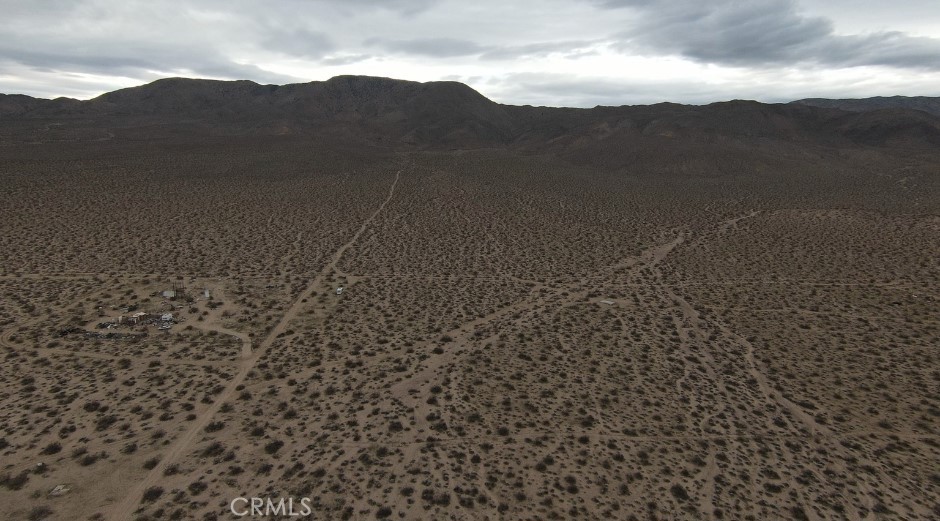a view of a dry yard with mountains in the background