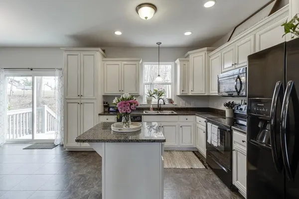 a kitchen with granite countertop a sink stove and cabinets