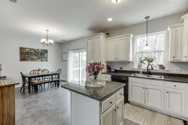 a kitchen with stainless steel appliances granite countertop a sink a stove top oven a counter space and cabinets