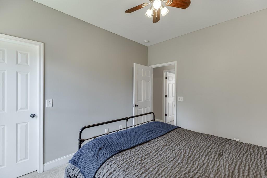 5050 Cagle Mill Road Lula, GA 30554 - Photo 22 of 48 a bedroom with a large bed and a chandelier