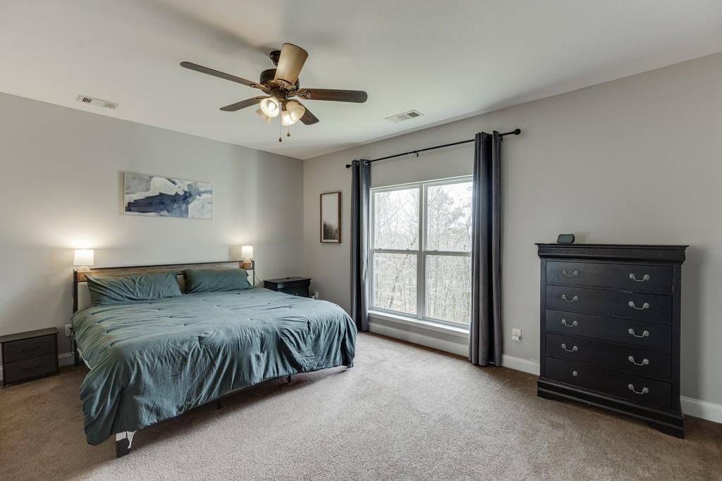 5050 Cagle Mill Road Lula, GA 30554 - Photo 28 of 48 a bedroom with a bed and a chandelier