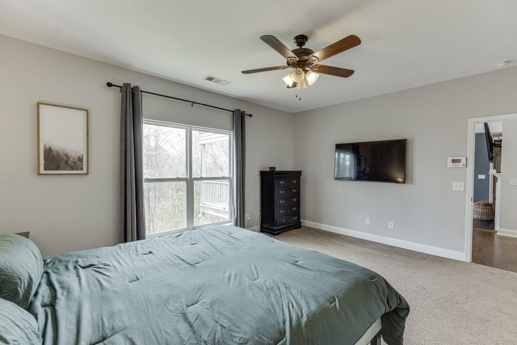 5050 Cagle Mill Road Lula, GA 30554 - Photo 31 of 48 a bedroom with a large bed and a flat screen tv