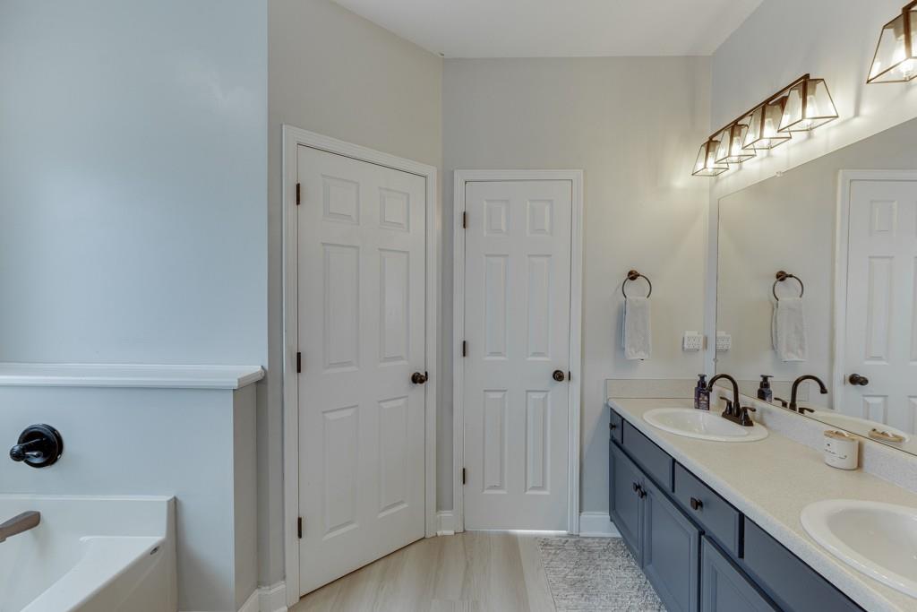 5050 Cagle Mill Road Lula, GA 30554 - Photo 32 of 48 a bathroom with double vanity sink a mirror and a bathtub
