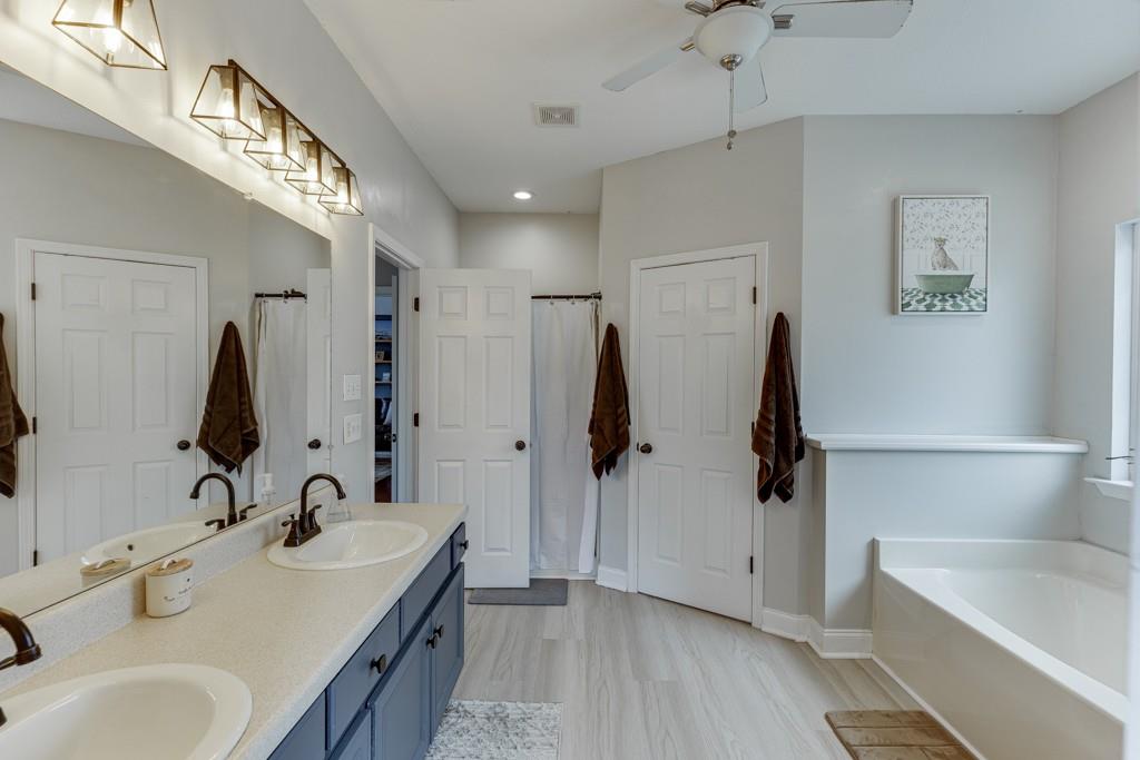 5050 Cagle Mill Road Lula, GA 30554 - Photo 33 of 48 a bathroom with 2 sink tub and a mirror