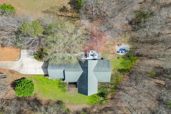 a aerial view of a house with a yard and large trees