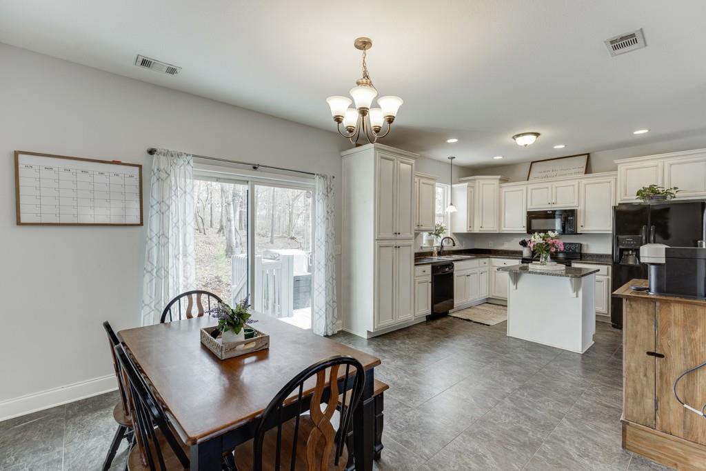 5050 Cagle Mill Road Lula, GA 30554 - Photo 10 of 48 a kitchen with granite countertop a table chairs stove and refrigerator