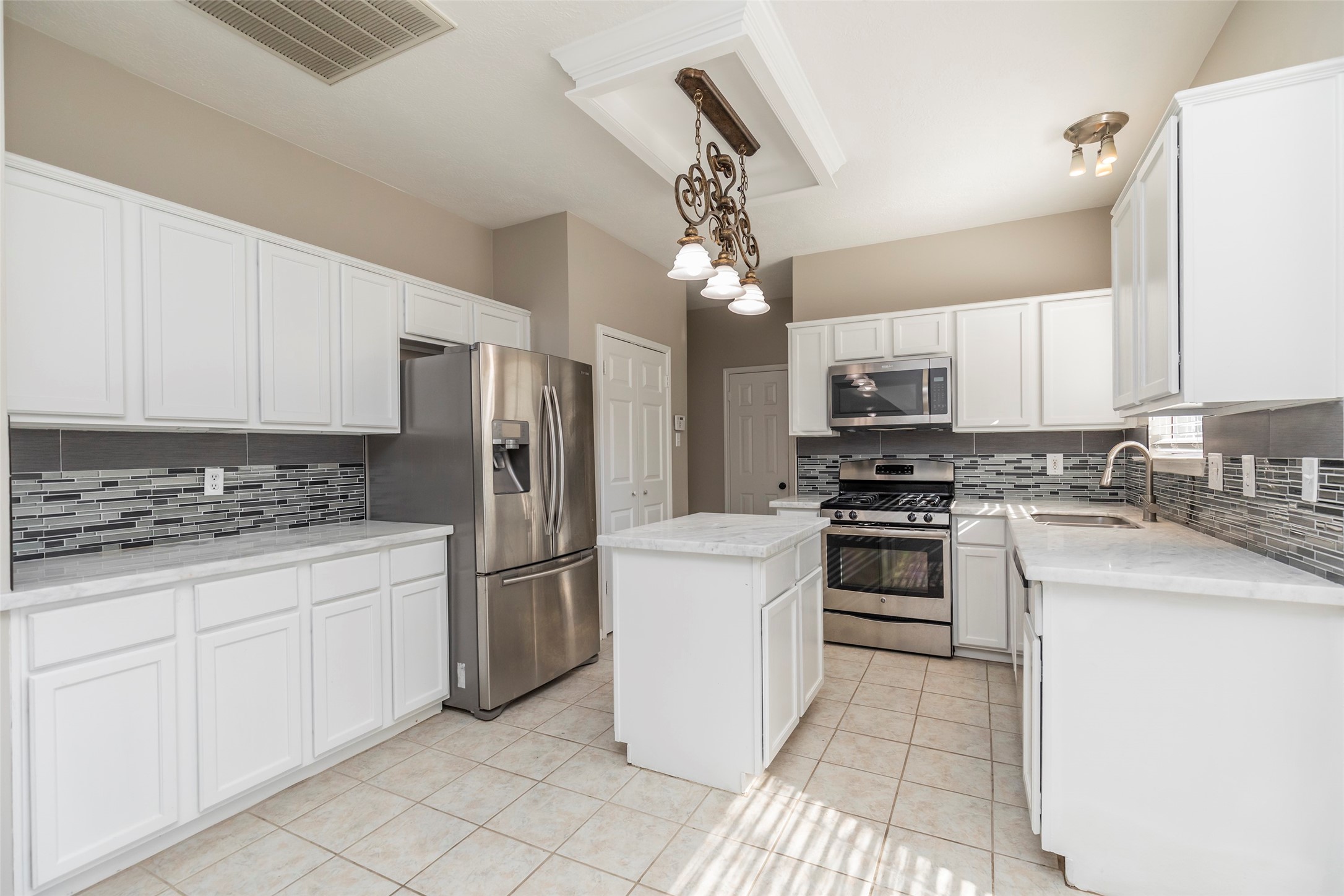 13110 Mills River Street Houston, TX 77070 - Photo 16 of 39 a kitchen with a refrigerator a stove top oven a sink and cabinets