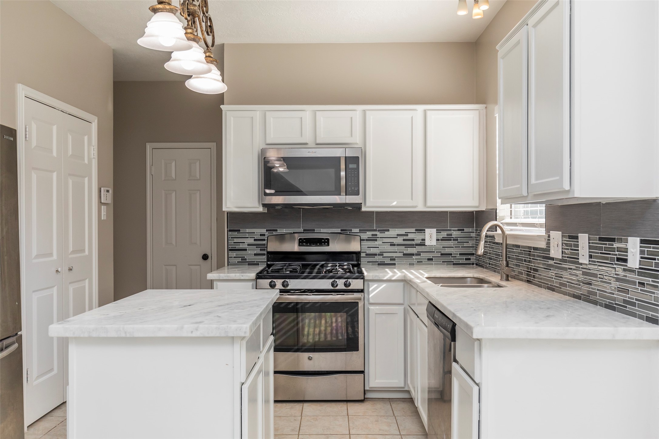 13110 Mills River Street Houston, TX 77070 - Photo 17 of 39 a kitchen with a stove and a microwave
