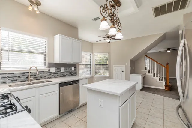 a kitchen with a stove a sink and a window