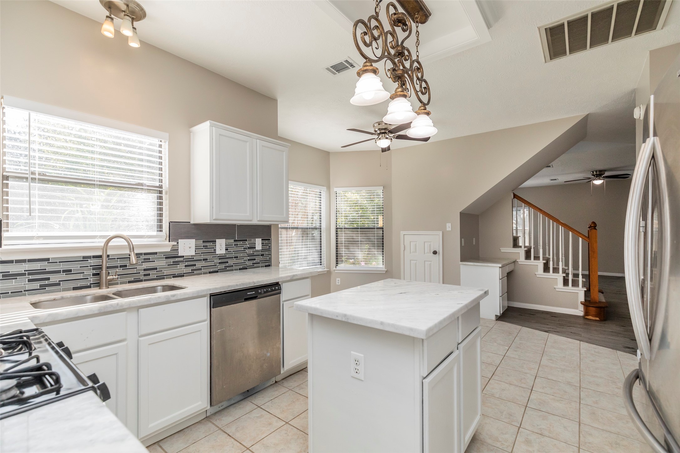 13110 Mills River Street Houston, TX 77070 - Photo 18 of 39 a kitchen with a sink a stove a chandelier and cabinets