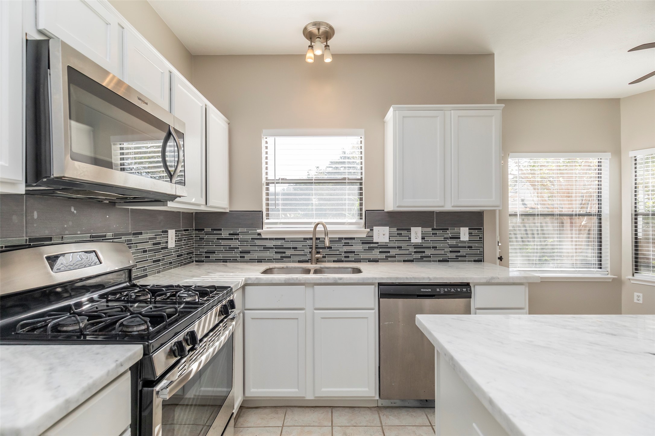 13110 Mills River Street Houston, TX 77070 - Photo 19 of 39 a kitchen with a stove a sink and a window
