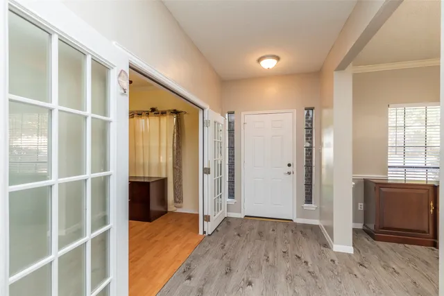 a view of empty room with wooden floor and windows