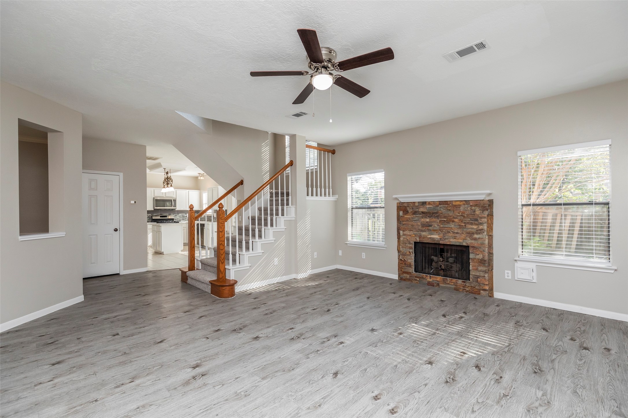 13110 Mills River Street Houston, TX 77070 - Photo 7 of 39 a view of an empty room with wooden floor a fireplace and a window