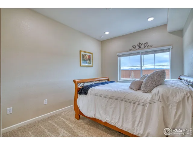 a bedroom with a bed and a large window