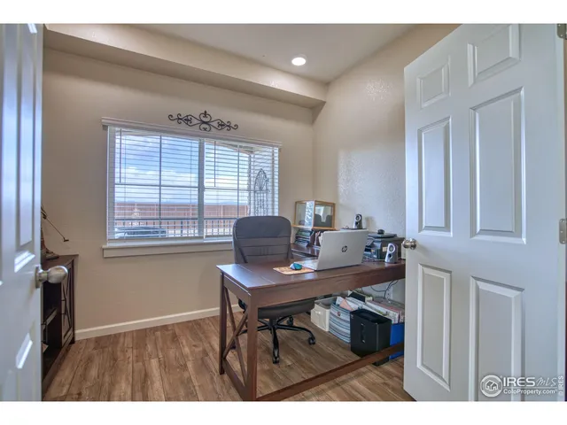 a view of a workspace with furniture and a window