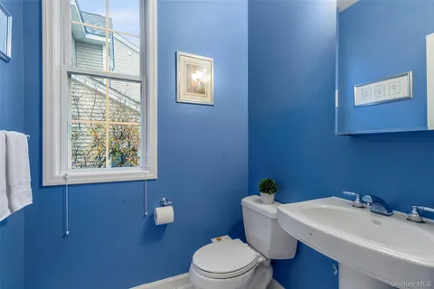 a bathroom with a sink a toilet and a window