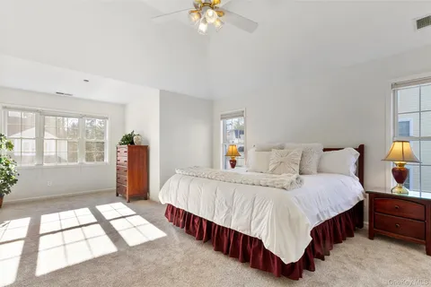 a bedroom with a large bed and a chandelier