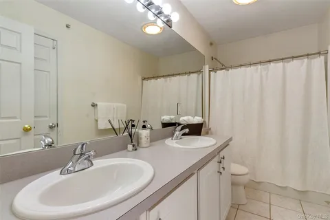 a bathroom with a granite countertop sink a toilet and a mirror