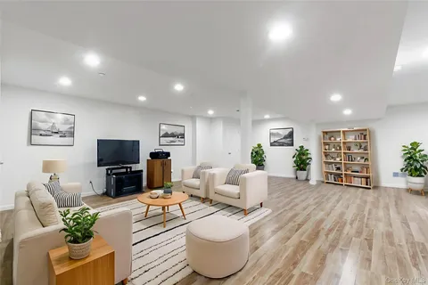 a living room with furniture a flat screen tv and a floor to ceiling window