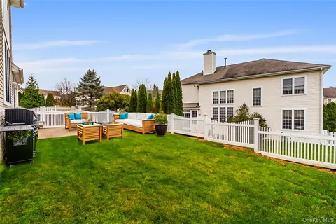 a view of a house with a backyard and chairs