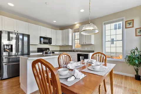 a kitchen with sink a refrigerator and chairs