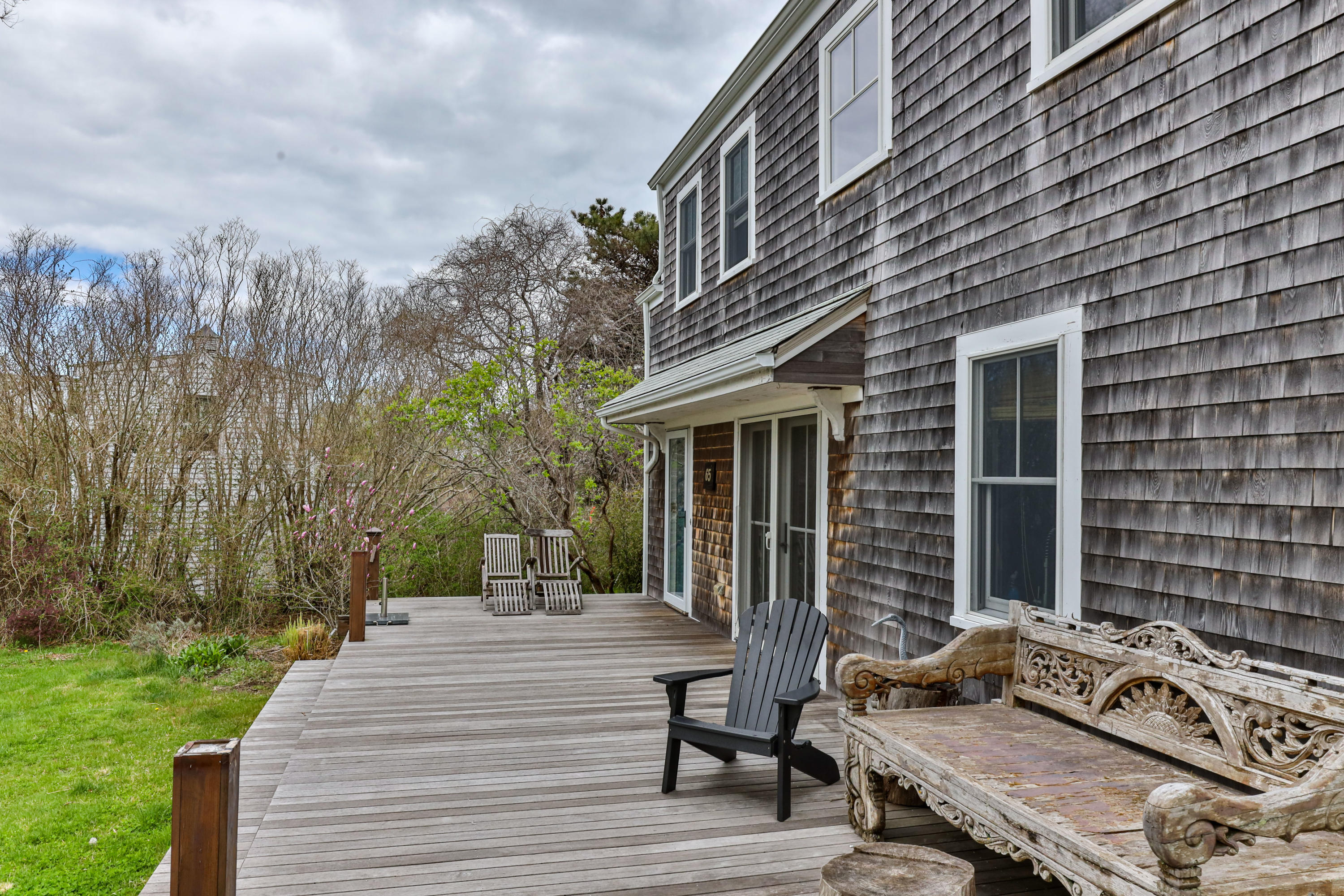 65 Depot Road Truro, MA 02666 - Photo 29 of 37 a view of a patio with table and chairs with wooden floor and fence