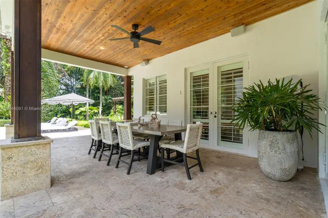 a view of a patio with a dining table and chairs with wooden fence