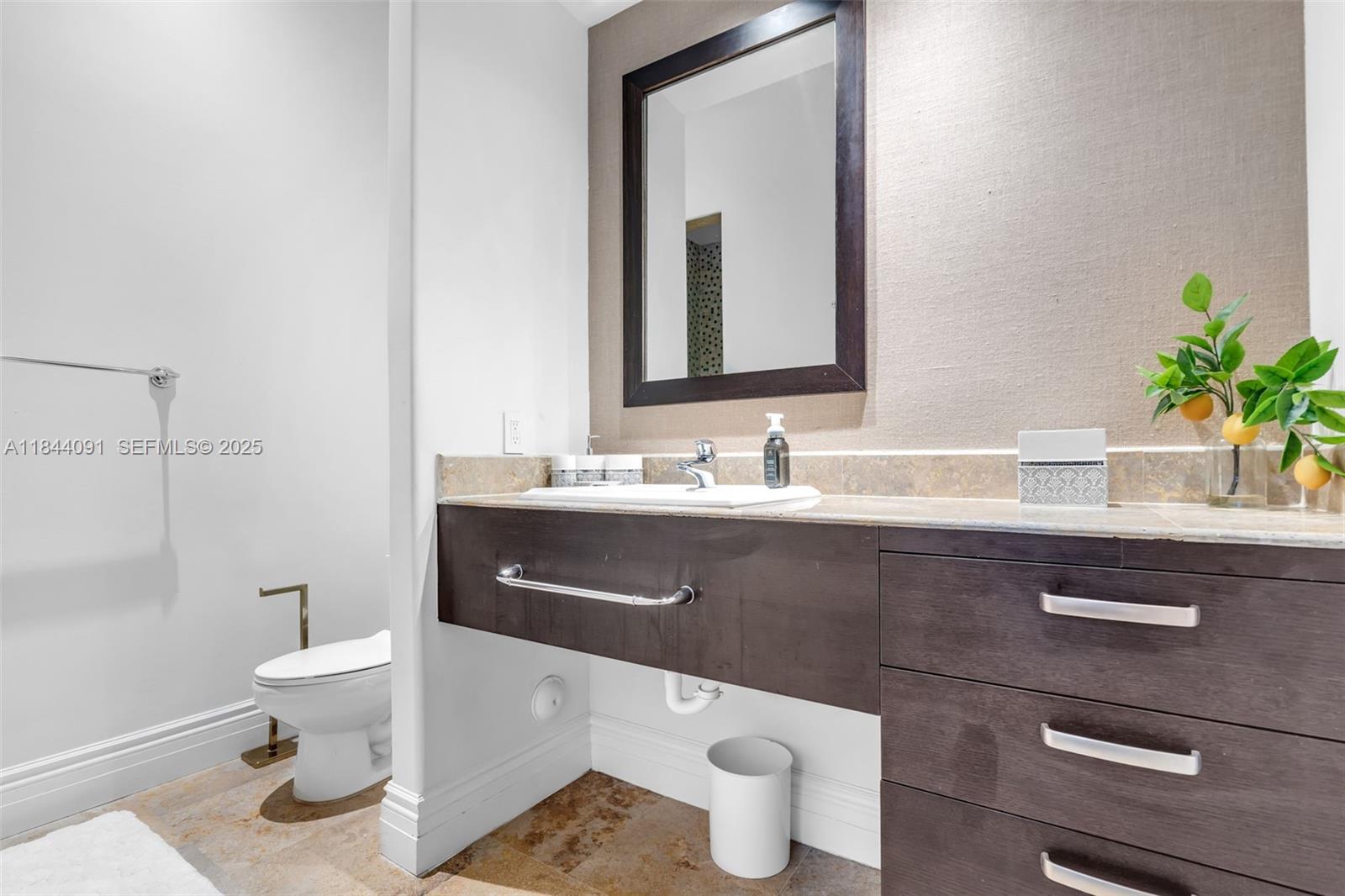 7320 Southwest 79th Court Miami, FL 33143 - Photo 52 of 89 a bathroom with a sink a toilet and a mirror