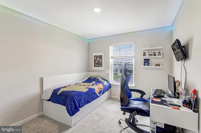 a bedroom with a bed and dresser with the shoe rack