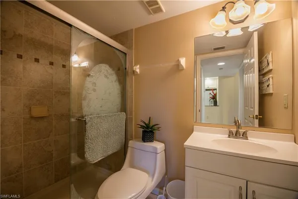 a spacious bedroom with a bed and a flat screen tv