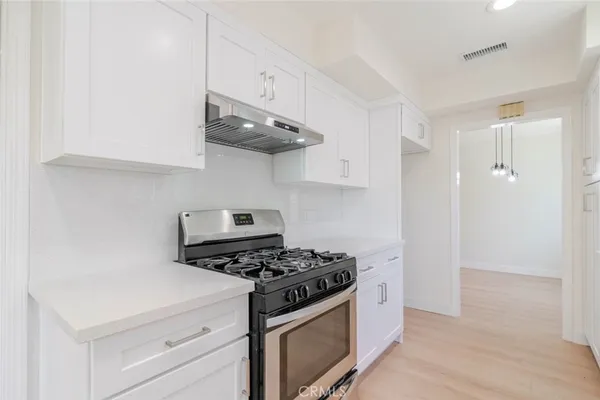 a kitchen with stainless steel appliances a white stove and cabinets
