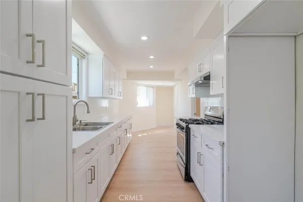 a kitchen with granite countertop a sink and a stove top oven