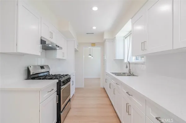 a kitchen with stainless steel appliances granite countertop a sink stove and cabinets