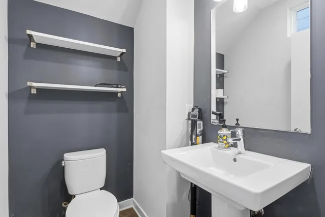 a bathroom with a toilet sink and mirror