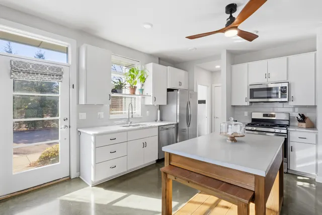 a kitchen with stainless steel appliances granite countertop a stove refrigerator sink and microwave