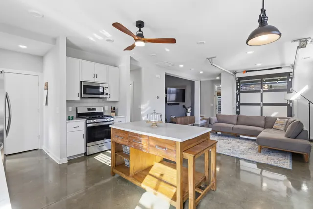 a kitchen with stainless steel appliances a stove a refrigerator a sink a stove with white cabinets