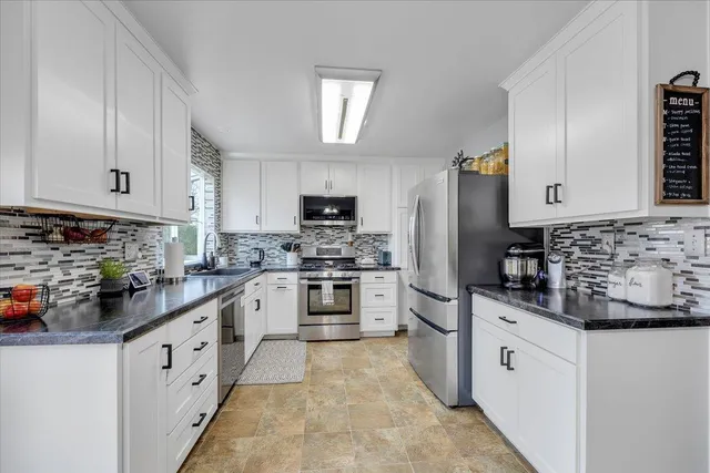 a kitchen with white cabinets and white appliances