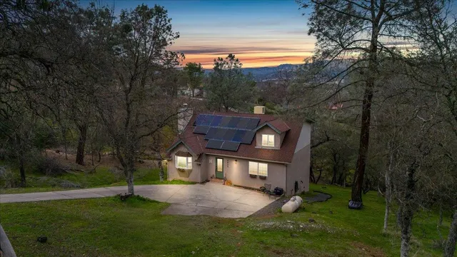a view of house with backyard and trees