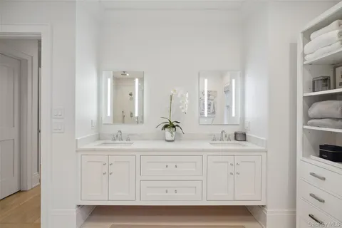 a bathroom with double sink and a mirror