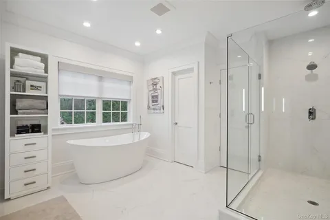 a bathroom with a tub a window and a shower