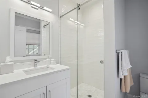 a bathroom with a shower sink and mirror