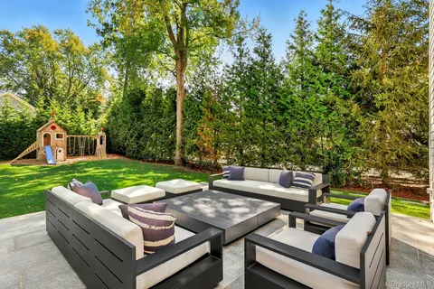 a view of a patio with couches and a table and chairs with garden view