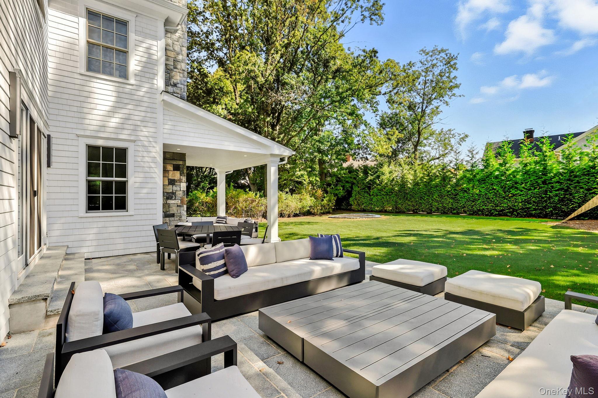 25 Hunt Place Rye, NY 10580 - Photo 40 of 44 a view of a patio with couches and a table and chairs with garden view