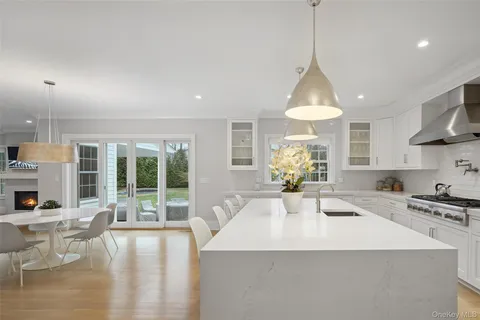 a kitchen with stainless steel appliances a table chairs and white cabinets