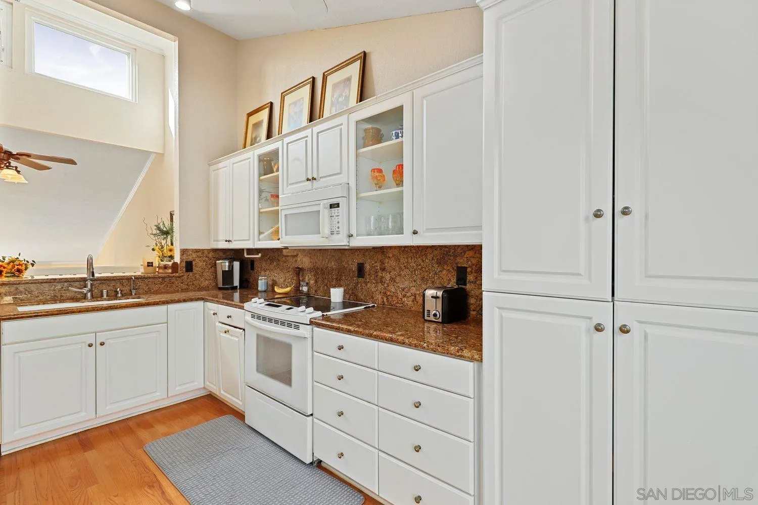 1818 Wilton Road Encinitas, CA 92024 - Photo 23 of 53 a kitchen with stainless steel appliances granite countertop white cabinets and sink