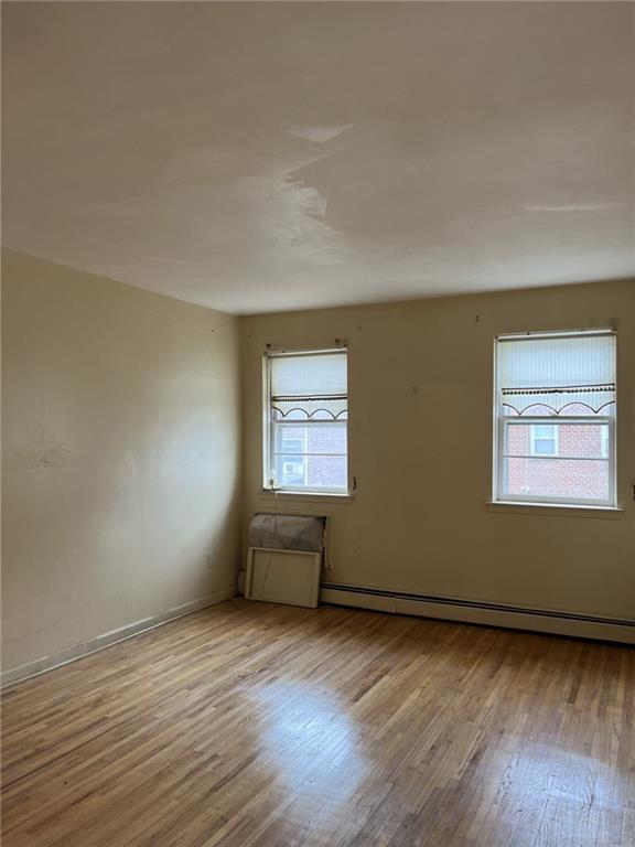 122 28th Avenue Brooklyn, NY 11214 - Photo 17 of 28 wooden floor in an empty room with a window