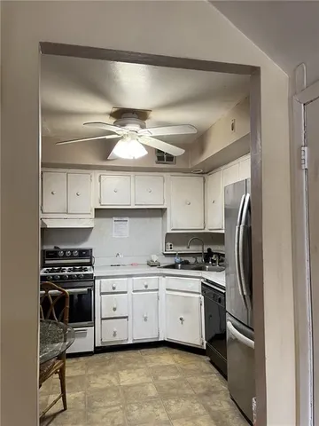 a kitchen with stainless steel appliances a stove a sink and cabinets