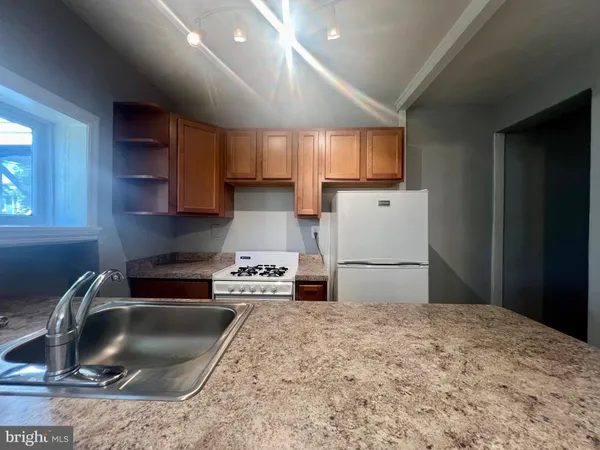 a kitchen with granite countertop a sink stainless steel appliances and cabinets